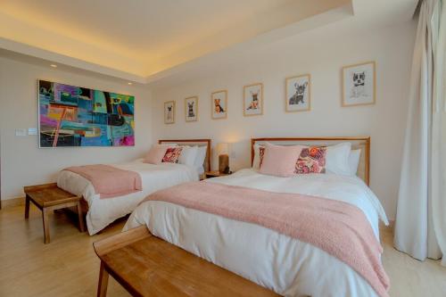 a bedroom with two beds and a painting on the wall at Villa Libertad, amazing pool ,modern design in El Infiernito
