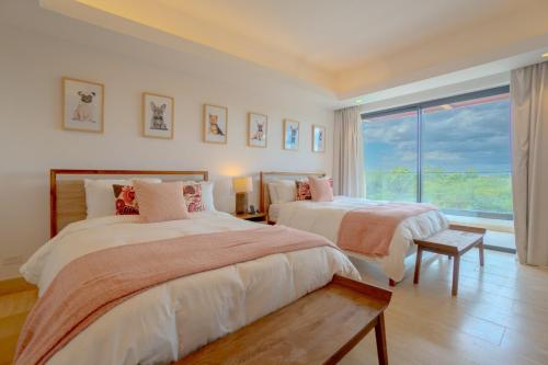 a bedroom with two beds and a large window at Villa Libertad, amazing pool ,modern design in El Infiernito