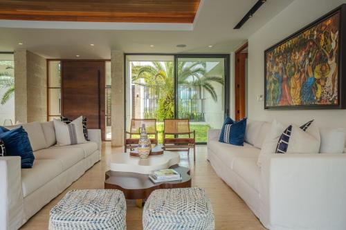 a living room with two white couches and a table at Villa Libertad, amazing pool ,modern design in El Infiernito