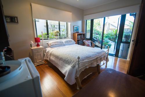 um quarto com uma cama e uma grande janela em Terry and Cindy's Bed and Breakfast em Auckland
