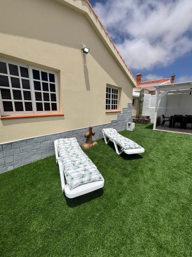 two beds on a lawn in front of a house at Casa Joy in La Oliva
