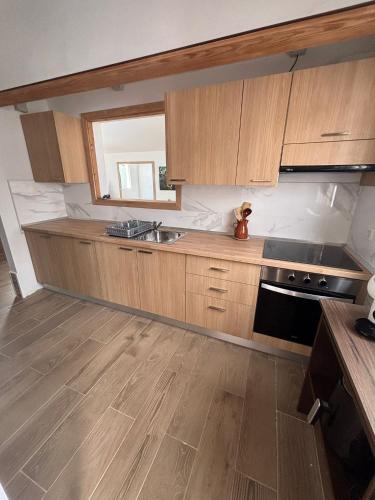 a kitchen with wooden cabinets and a sink and a stove at Casa Joy in La Oliva