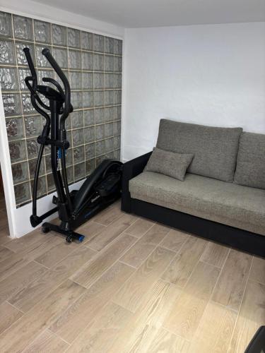a living room with a couch and a exercise bike at Casa Joy in La Oliva