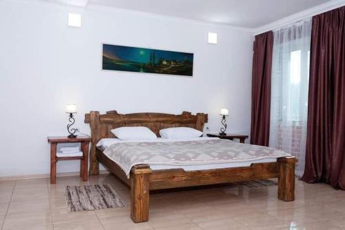 a bedroom with a large wooden bed with two tables at Fortetsya "Стабільне електропостачання!" in Umanʼ