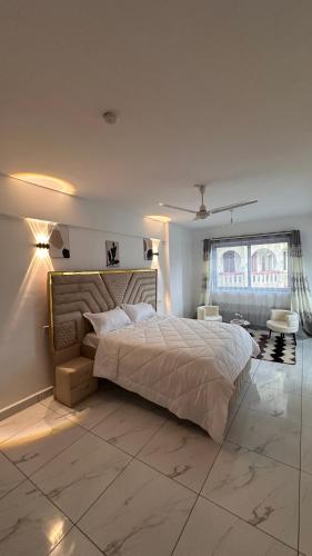 a bedroom with a large bed and a window at Zuri Stay in Mombasa