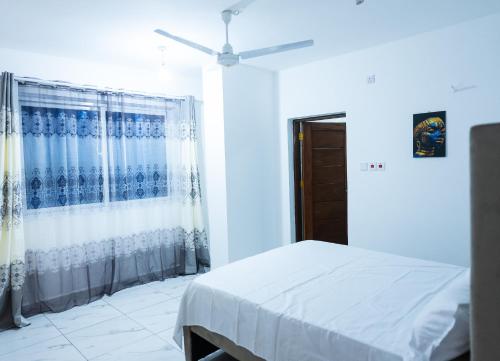 a bedroom with a bed and a ceiling fan at Zuri Stay in Mombasa