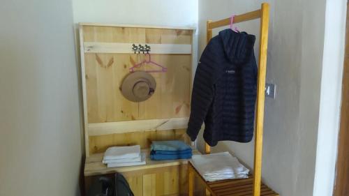 a small room with a bed and a clothes rack at Lharimo North Cottages - Nubra Valley in Wāhegaon