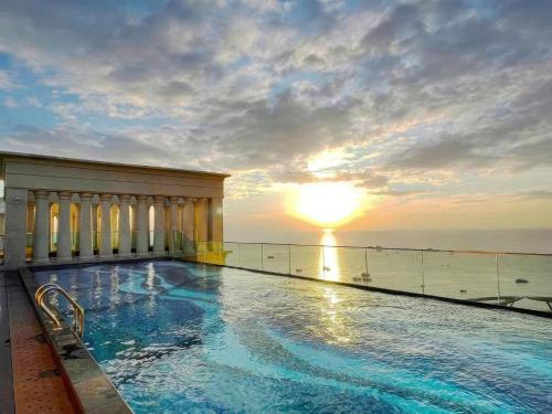 a swimming pool on top of a building with the sunset at Hillside residence Phu Quoc, sea &firework view in Phu Quoc