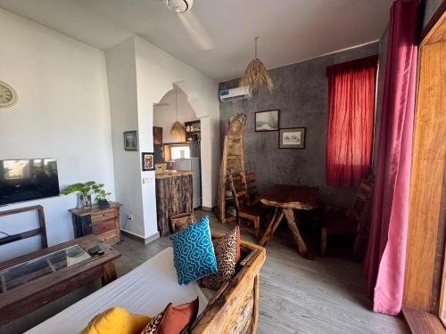 a living room with a couch and a table at Villa KipepeoO in Kendwa