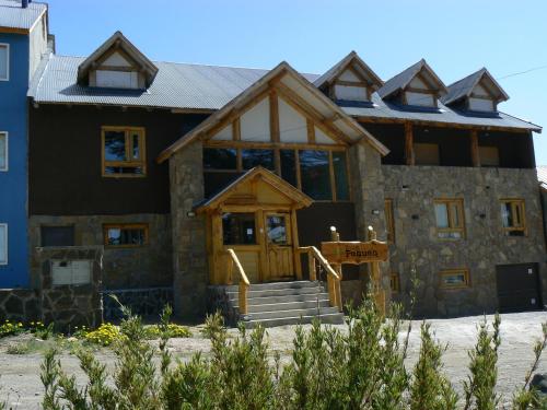 a large house with a wooden door in front of it at Ruca Pehuen Eco-Lodge De Montaña in Caviahue