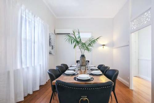 a dining room with a table and black chairs at Central Haven Milton 4BR Sleeps 10 in Brisbane