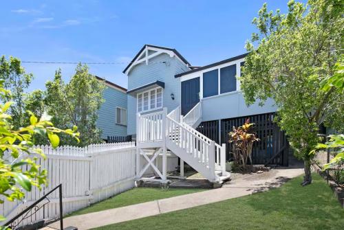a blue and white house with a white fence at Central Haven Milton 4BR Sleeps 10 in Brisbane