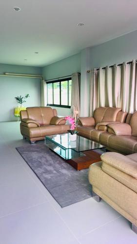 a living room with couches and a glass table at Homey At The Dam, Private House in Ban Ta Khun