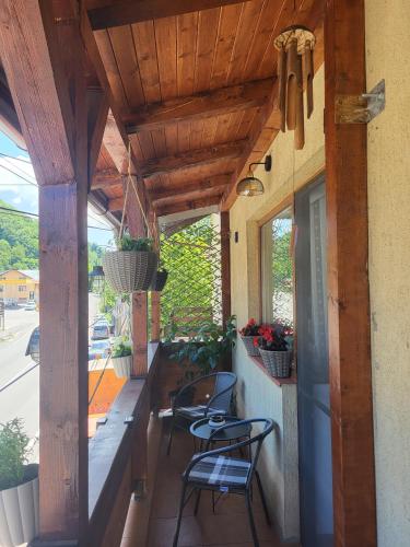 a porch with two chairs and a table and some plants at La Simo in Sinaia