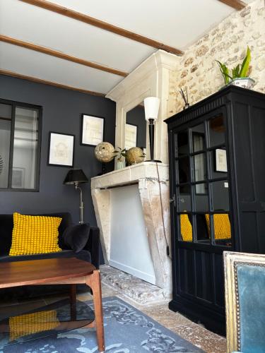 a living room with a fireplace and a black cabinet at Appartement Talmont sur Gironde in Talmont