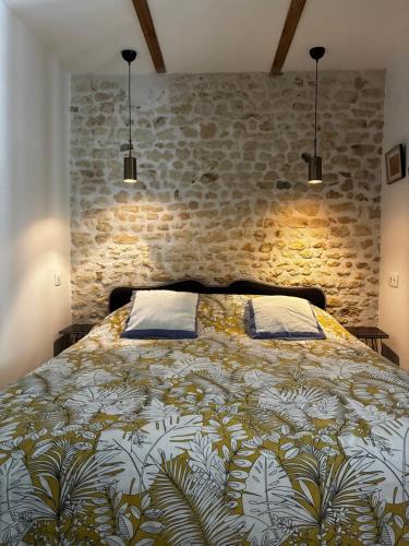 a bedroom with a large bed with a stone wall at Appartement Talmont sur Gironde in Talmont