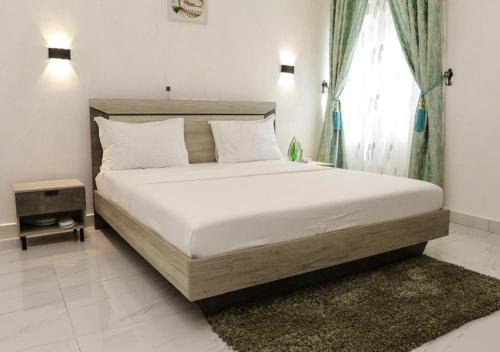 un letto grande in una camera da letto con finestra di Akwuaba a Brazzaville