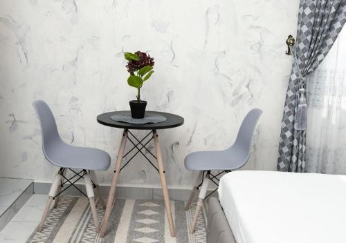 un tavolo con due sedie e una pianta in vaso sopra di Akwuaba a Brazzaville
