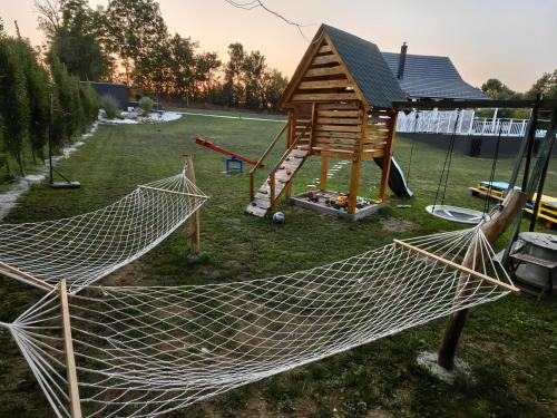 a hammock in a yard with a playground at Moje srećno mesto in Arandjelovac