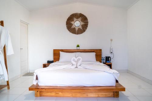 a bedroom with a white bed with a bow on it at pohon cinta glamping in Baturaja