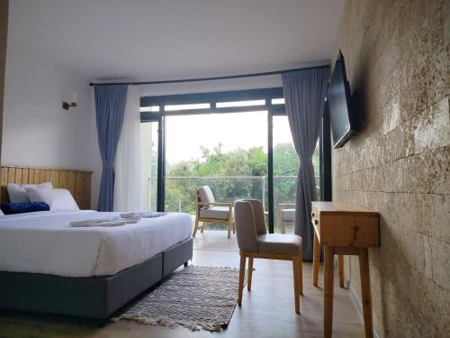 a bedroom with a bed and a view of a balcony at Idan Barn Suites and Café in Nyeri