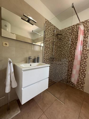 a bathroom with a white sink and a shower at NEW Apartment Ema II in Vrh