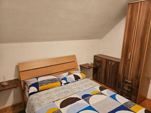 a bedroom with a bed with a wooden headboard at Give Peace a Chance - 10 km from Sarajevo City Center in Petrovići