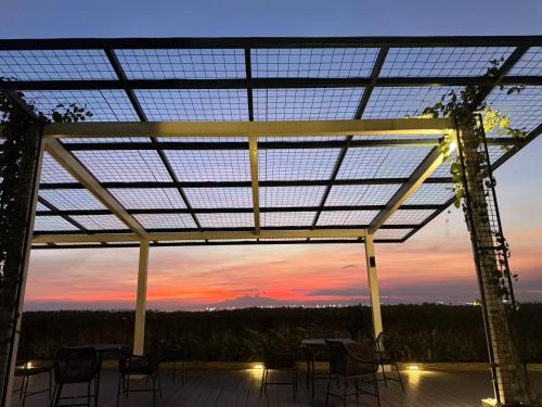 a patio with tables and chairs and a sunset at Perfect 1BR With Magnificant Bayview Garden View Near Okada, Solaire, Aiports, FREE PARKING in Manila