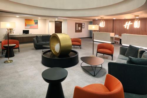 a lobby with couches and chairs and a table at Holiday Inn Hotel & Suites Mexico Medica Sur by IHG in Mexico City
