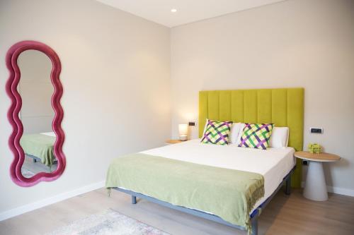 a bedroom with a bed and a mirror at Zabella Ossau - Nuevo ático a estrenar en el tubo in Zaragoza