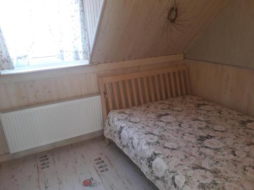 a small bedroom with a bed and a window at Apartment Nautilus in Jūrmala