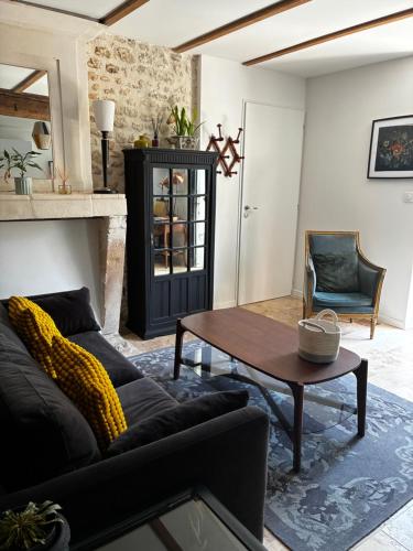 a living room with a black couch and a table at Appartement Talmont sur Gironde in Talmont