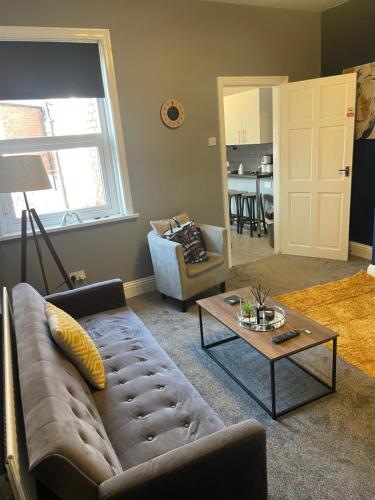 a living room with a couch and a table at Affordable Luxury 4 Stunning apartment Sunderland close to City centre hospital Crown Works Studio and Nissan in Sunderland