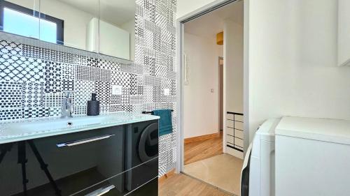 a bathroom with a sink and a washing machine at 3star 1950s house, 3 bedrooms, 6 people, walk to beach center in Royan