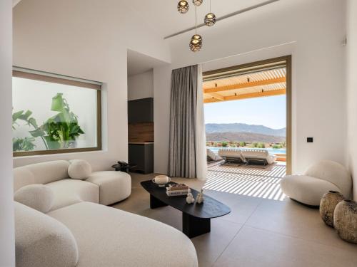 a living room with a couch and a table at Panormos Bay Collection Mykonos in Panormos Mykonos