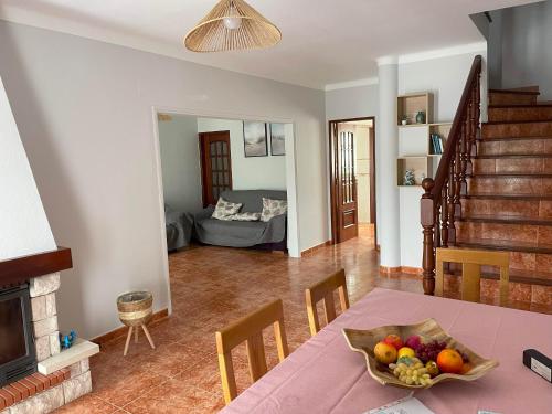 a living room with a table with a bowl of fruit at Refúgio do Mira in Vila Nova de Milfontes