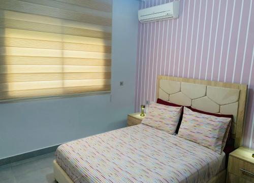 a bedroom with a bed and a window at Appart Cosy Résidence Perla in Saïdia