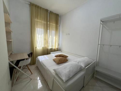 a small white bedroom with a bed and a chair at Dreaming About Italy in Torre Annunziata