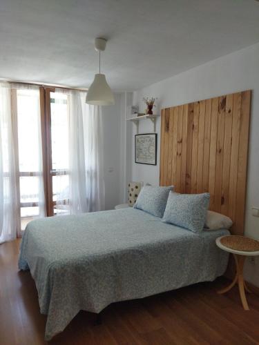 a bedroom with a large bed with blue pillows at El Mirador de la Estación in Canfranc-Estación