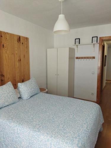 a bedroom with a bed with a blue comforter at El Mirador de la Estación in Canfranc-Estación