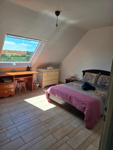 a bedroom with a bed and a desk and a window at Les chambres de la Vallée Cachée in Callac