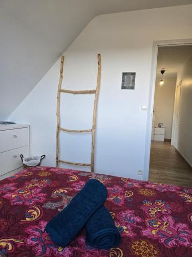 a bed with two blue towels on top of it at Les chambres de la Vallée Cachée in Callac