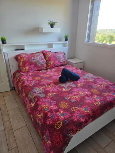 a bedroom with a bed with a red comforter at Les chambres de la Vallée Cachée in Callac