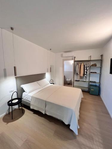 a bedroom with a large white bed and a closet at Mariposa Rooms in San Teodoro