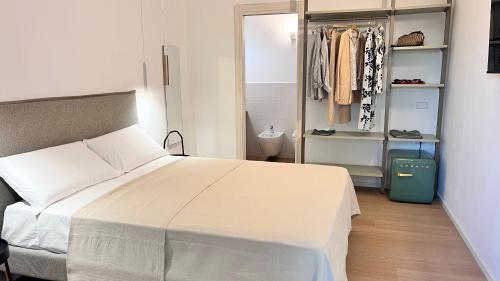 a bedroom with a large white bed and a closet at Mariposa Rooms in San Teodoro
