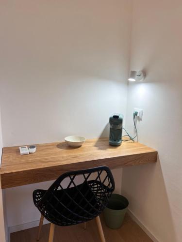 a wooden table with a black chair under a desk at Mariposa Rooms in San Teodoro