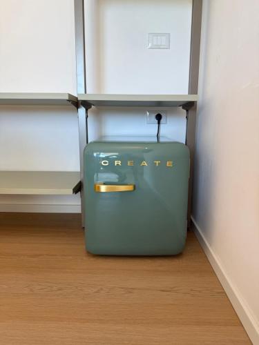 a green suitcase sitting on the floor in a room at Mariposa Rooms in San Teodoro