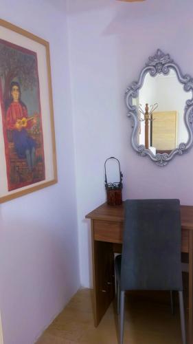 a desk with a chair and a mirror on a wall at Anastelia Apartments - The Backyard in Olympiada