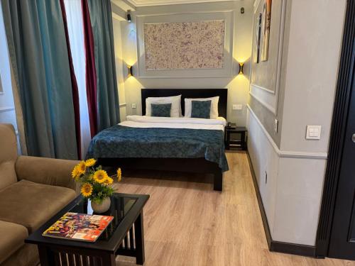 a bedroom with a bed and a couch and a table at Vitrage Hotel Baku in Baku