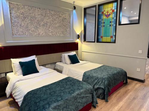 a hotel room with two beds and a window at Vitrage Hotel Baku in Baku